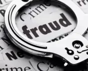 close-up image of handcuffs placed over a newspaper