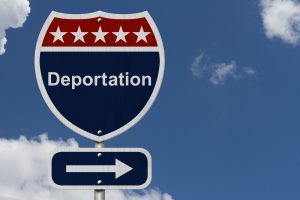 deportation road sign with background clouds