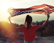immigrant holding up a US flag