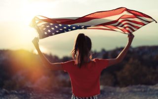 immigrant holding up a US flag