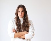 serious hispanic woman standing with arms crossed