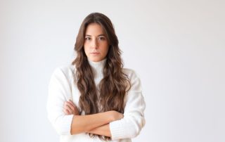 serious hispanic woman standing with arms crossed